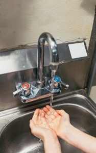 Hands being washed in a sink