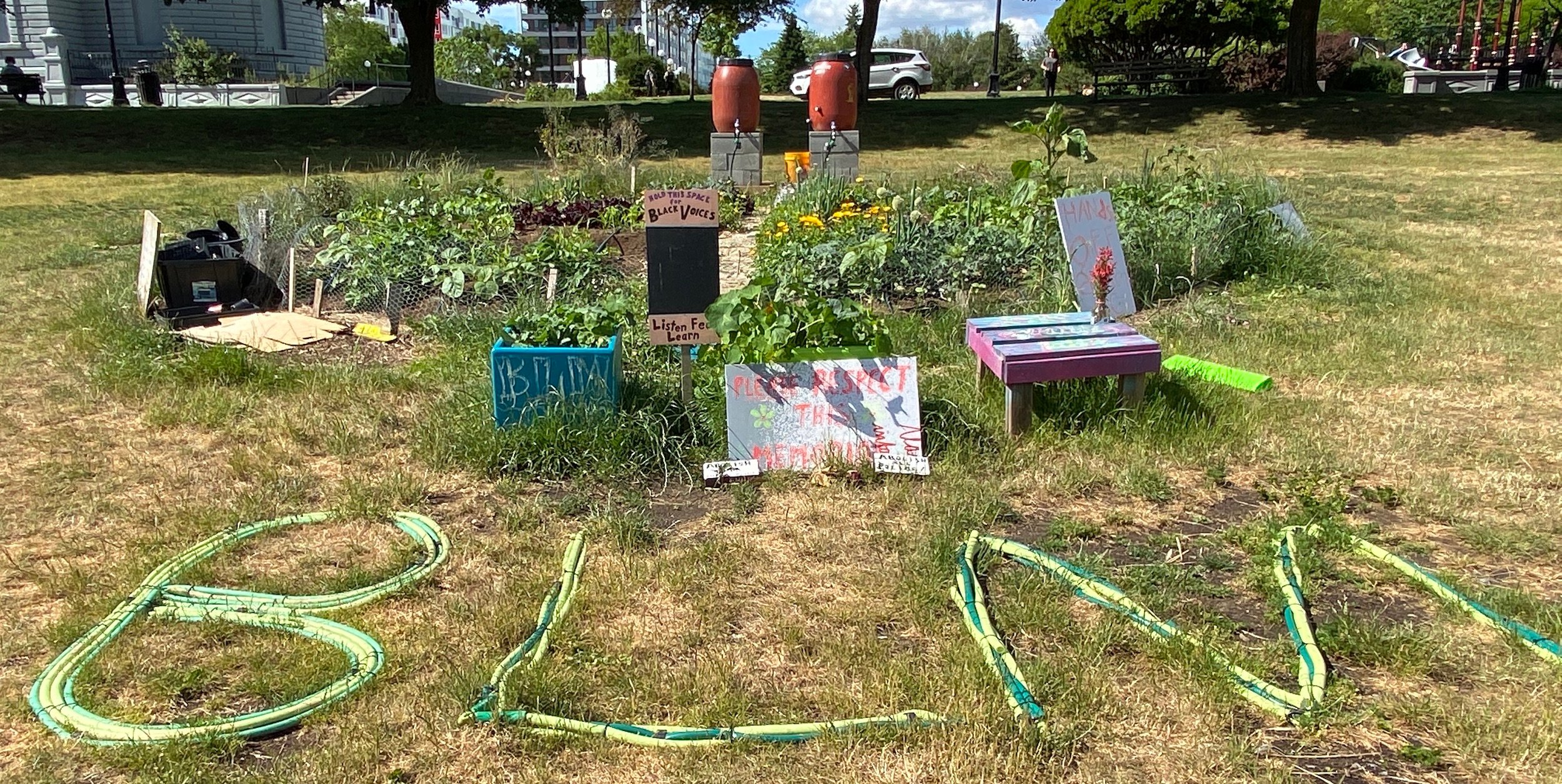 The letters BLM are arranged in front of the Cal Anderson Park Garden
