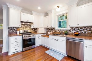 The updated kitchen includes custom cabinets and stainless steel appliances