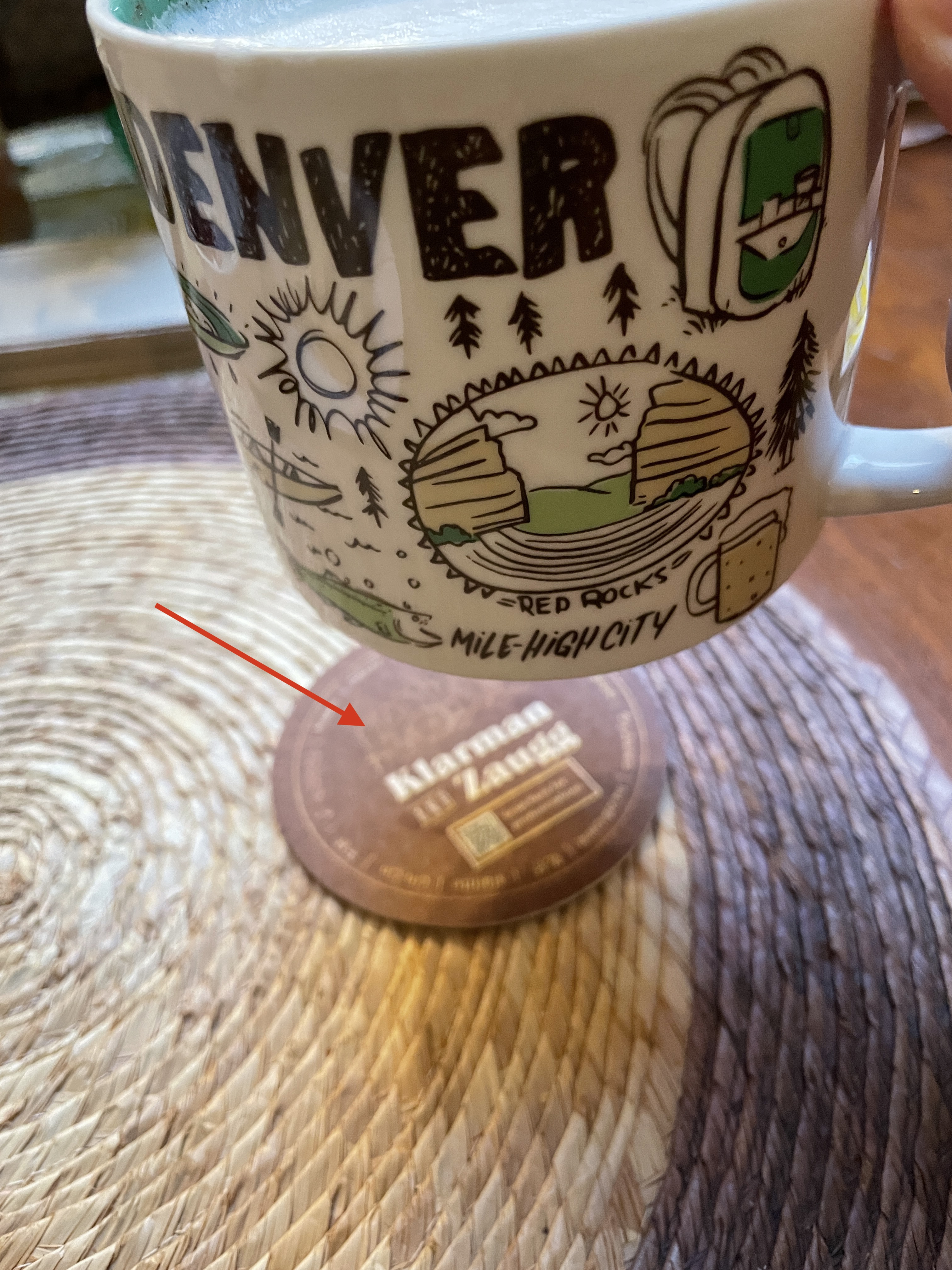 A Denver mug hovers over a Klarman & Zaugg coaster