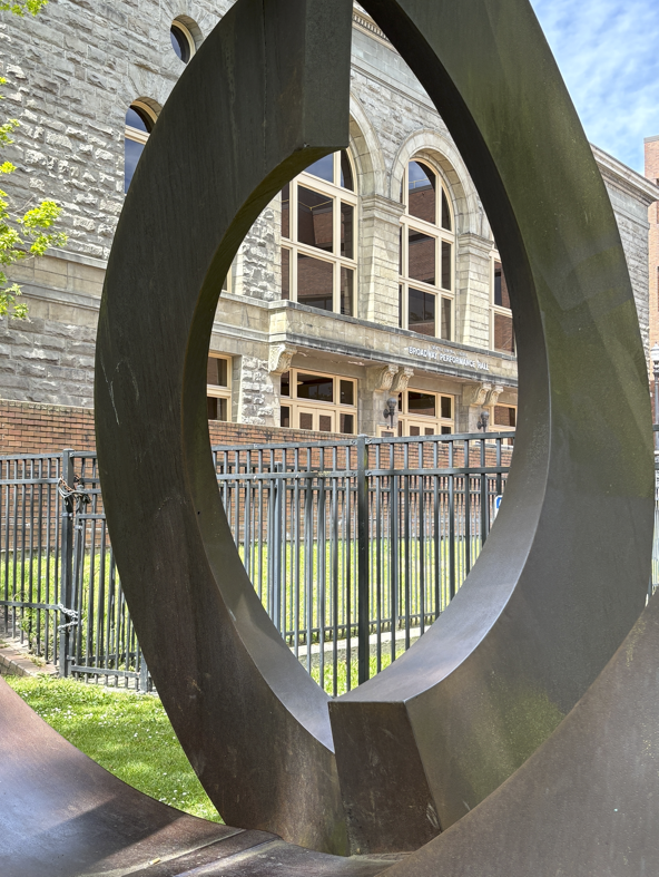 Broadway Performance Hall Viewed through Park Sculpture by Charles W Smith