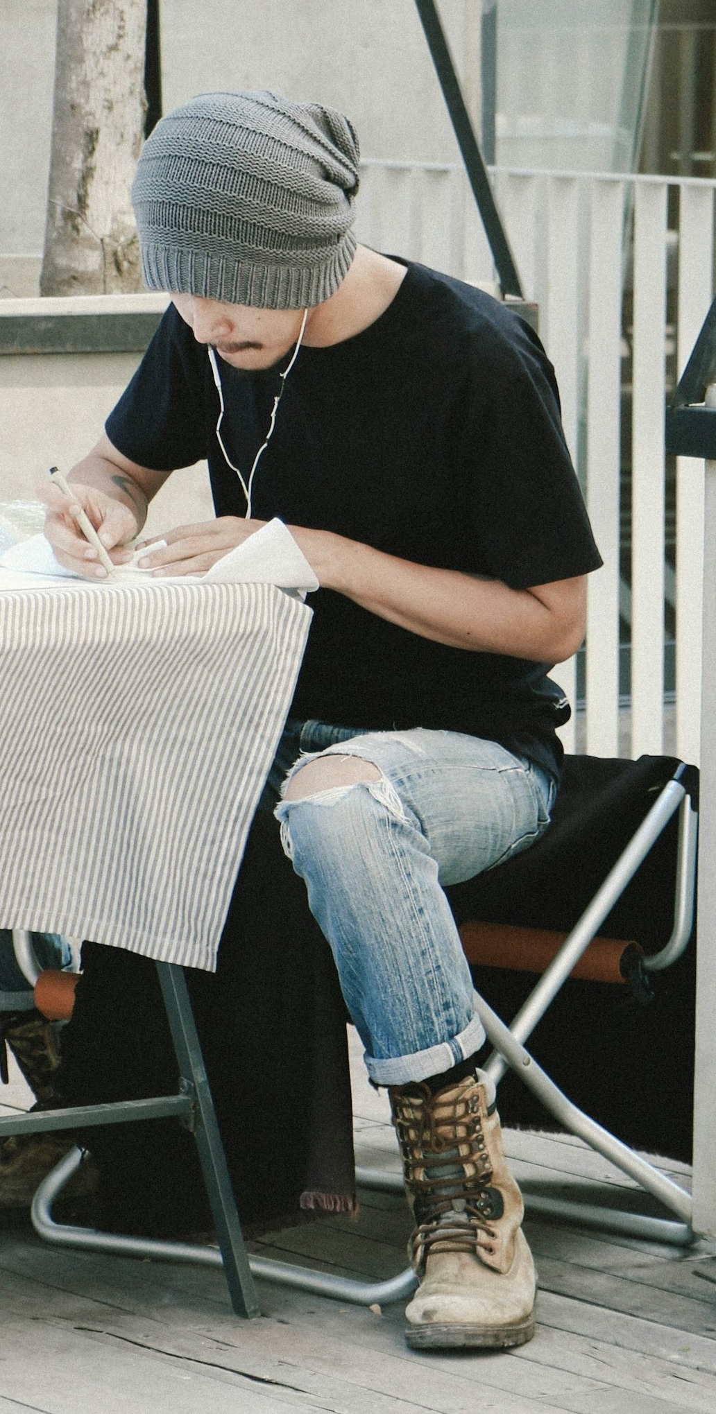 A man signing a document while listening to music