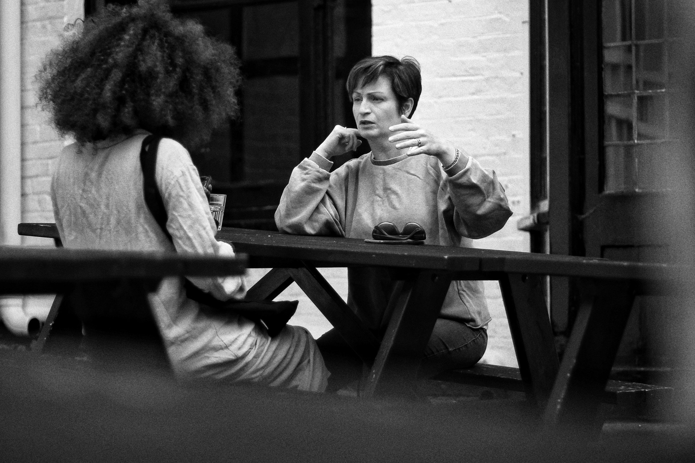 Two women talking at a picnic table