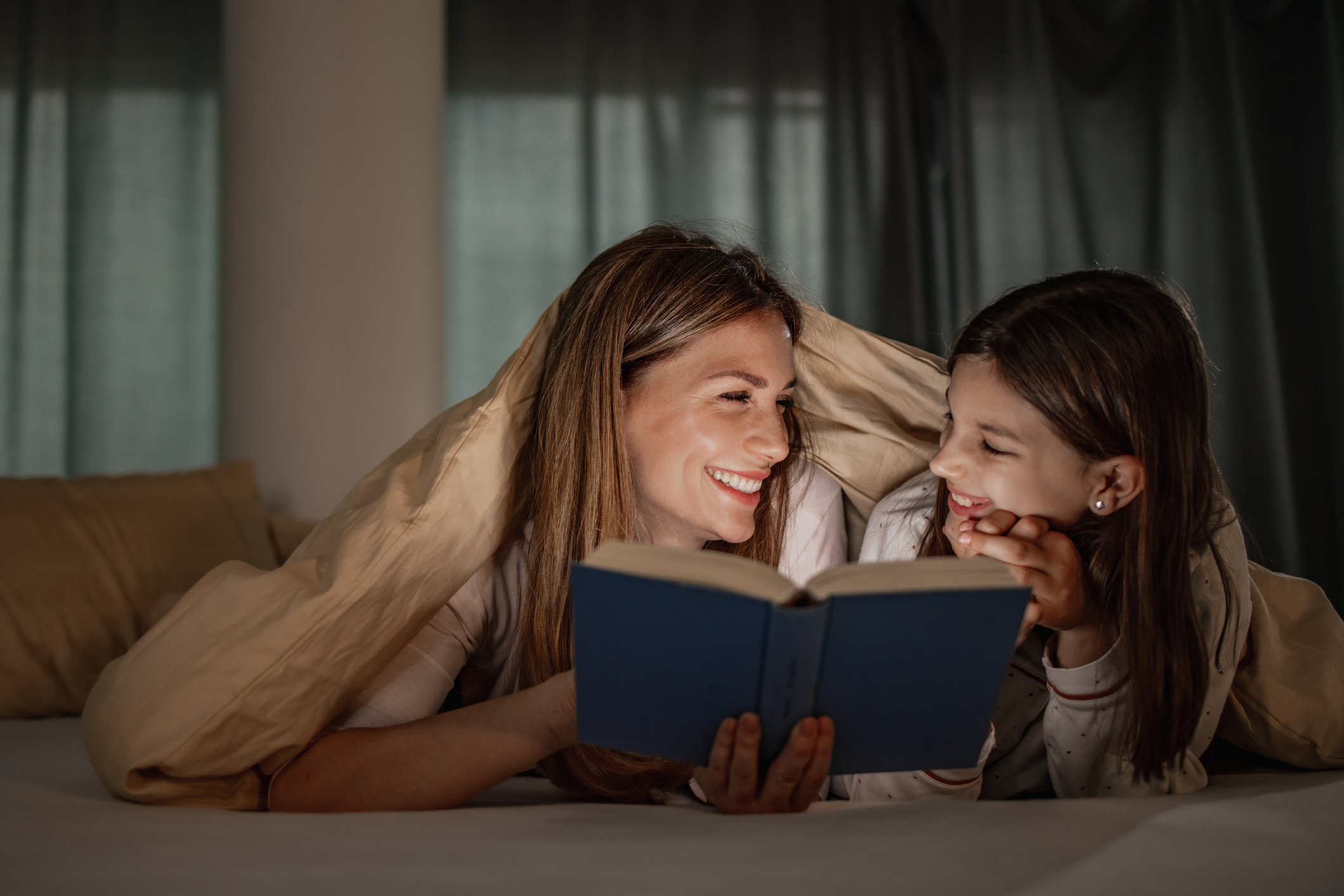 mom and daughter share a book