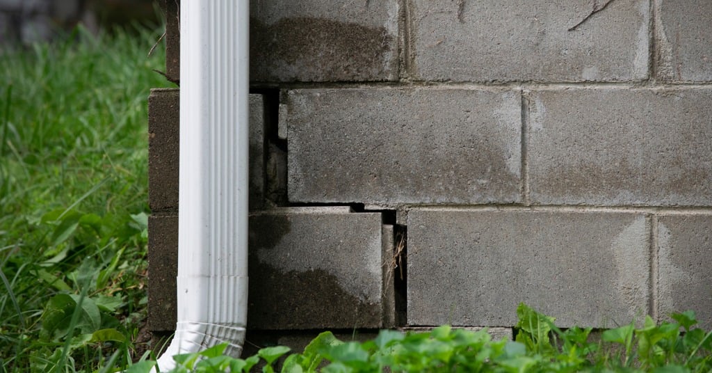 Foundation crack with moisture staining indicating potential structural and water-intrusion risk.