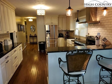 White kitchen with stainless steel appliances inside kitchen in a home for sale in Boone, NC