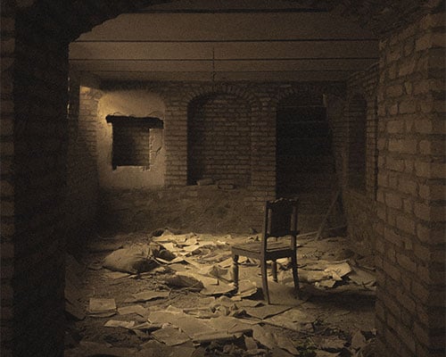 A dark and dirty unfinished basement cellar with no windows.