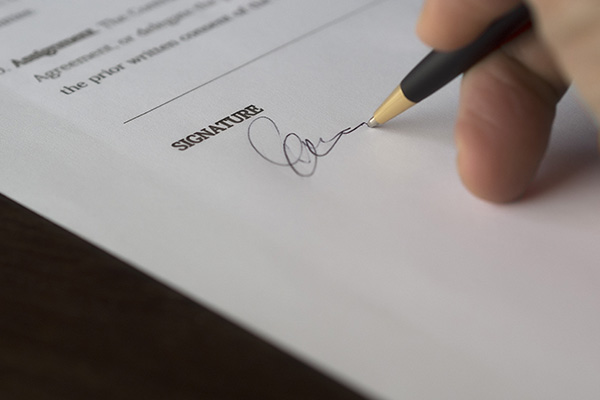 Real estate seller signing a property listing agreement