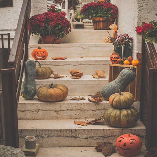 Halloween decor and jackolaterns on a porch step
