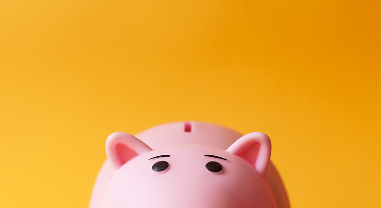 Close-Up Of Pink Piggy Bank Against Orange Background