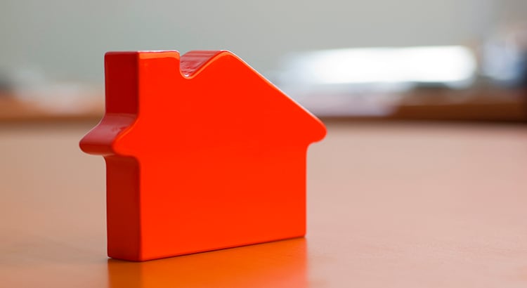 Close up view of a red plastic miniature house on a table