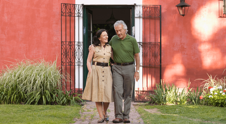 An older couple walking on their front walkway