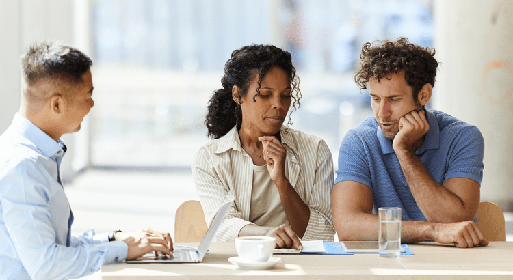 A couple at the closing table with their real estate agent