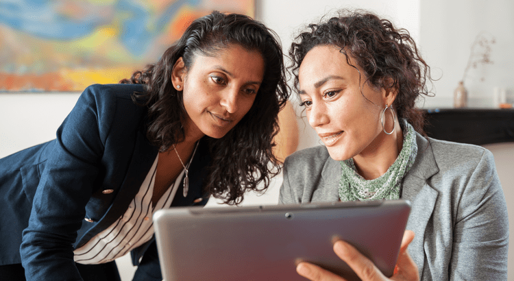 Two women looking at a laptop screen.