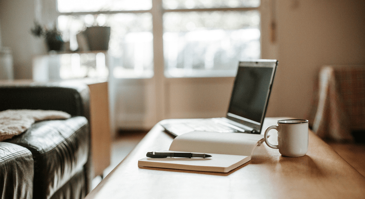 Laptop and notebook on a coffee table.