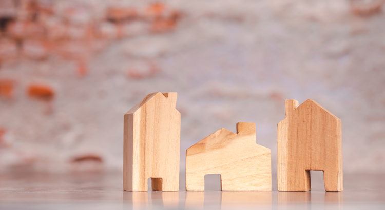 Houses as wooden blocks against a brick background