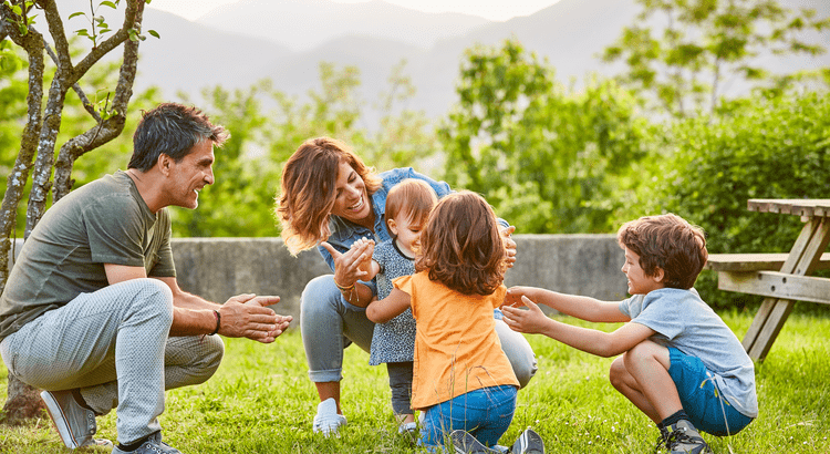 Family with youn children playing in the backyard