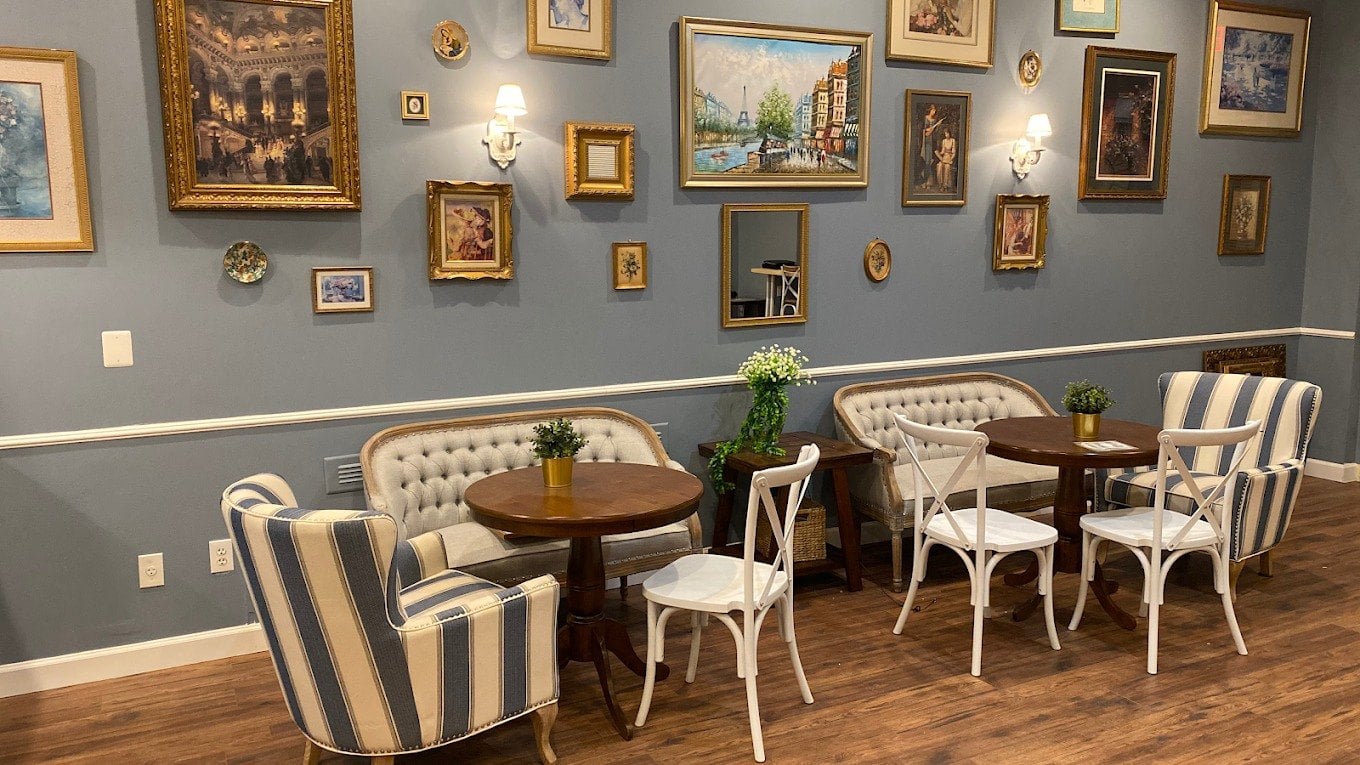 Dining room at Le Vingt Trois Cafe and Bakery in Herndon with framed paintings and striped armchairs