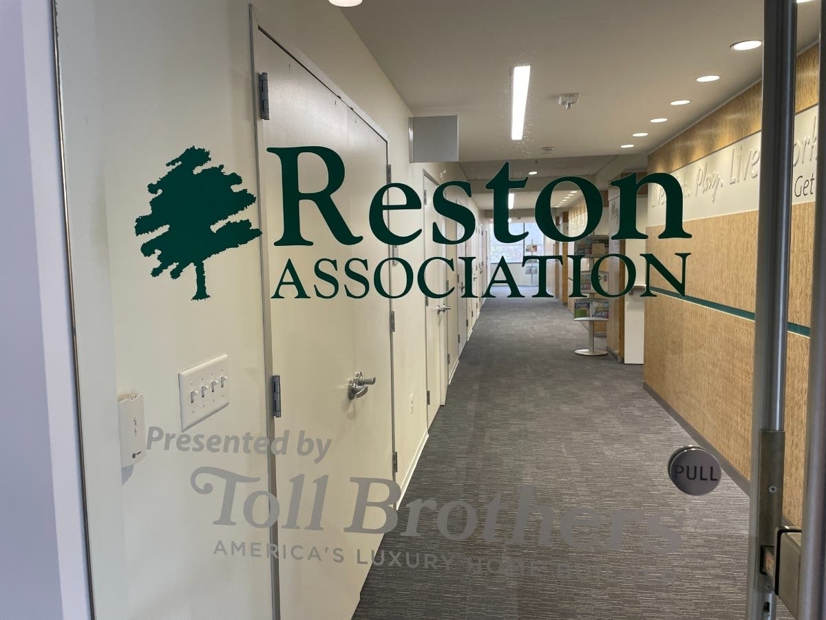 The glass entrance door at Reston Association headquarters on Sunrise Valley Drive in Reston, Virginia, etched with the Reston Association tree logo