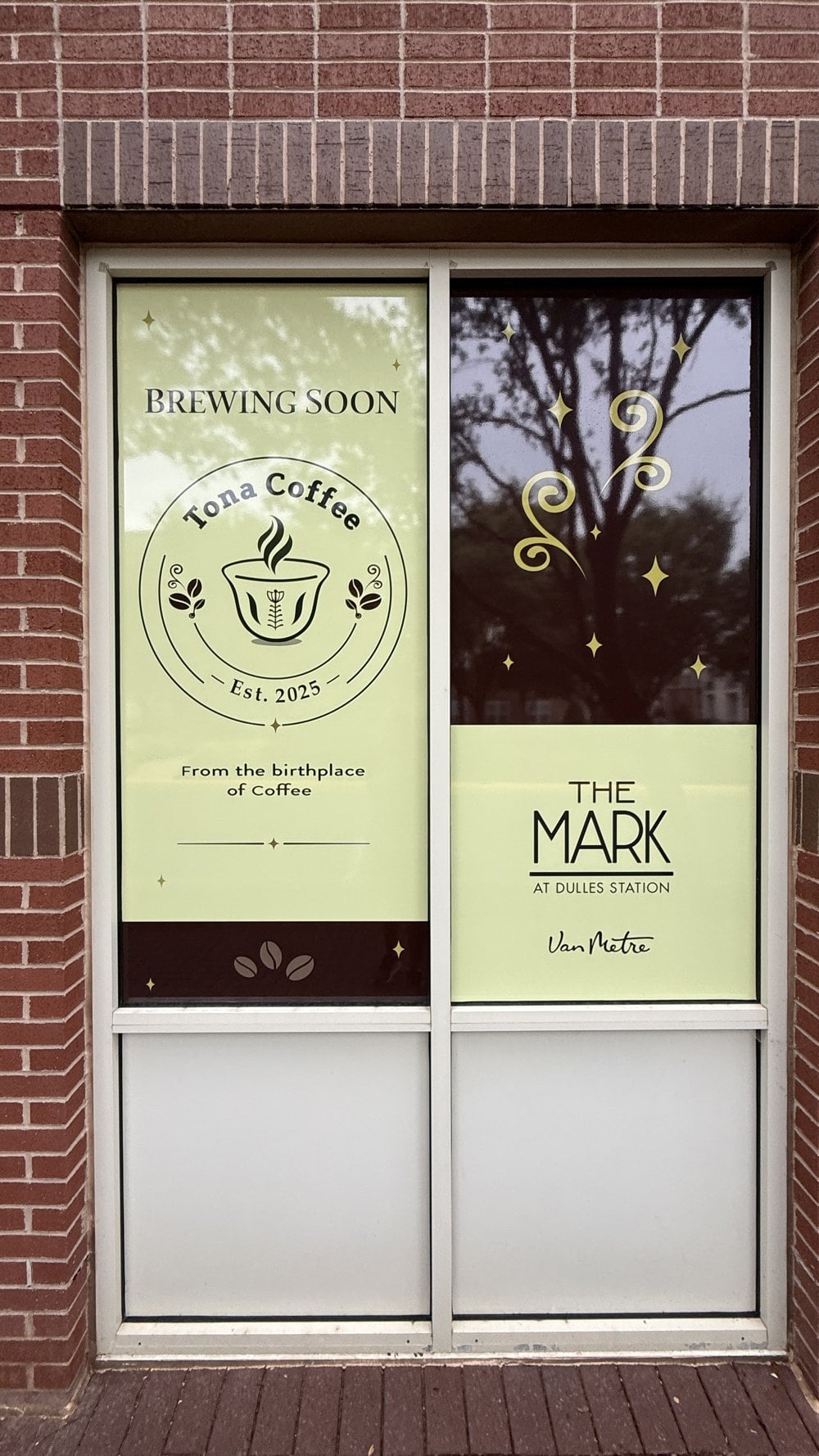 Tona Coffee window sign reading Brewing Soon, Est. 2025, From the birthplace of Coffee, at The Mark at Dulles Station in Herndon