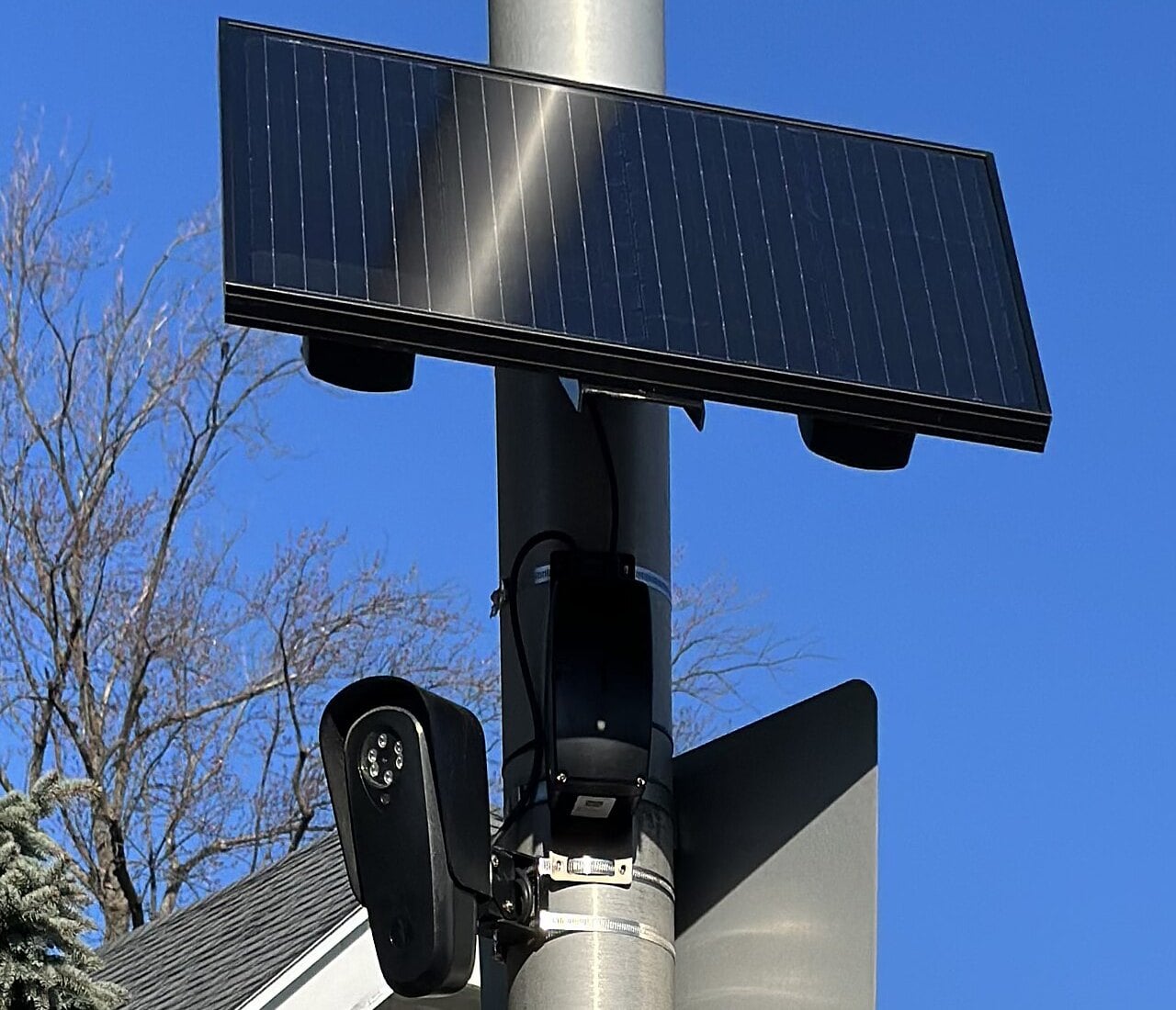 Flock Safety license plate reader camera and solar panel mounted on a street pole
