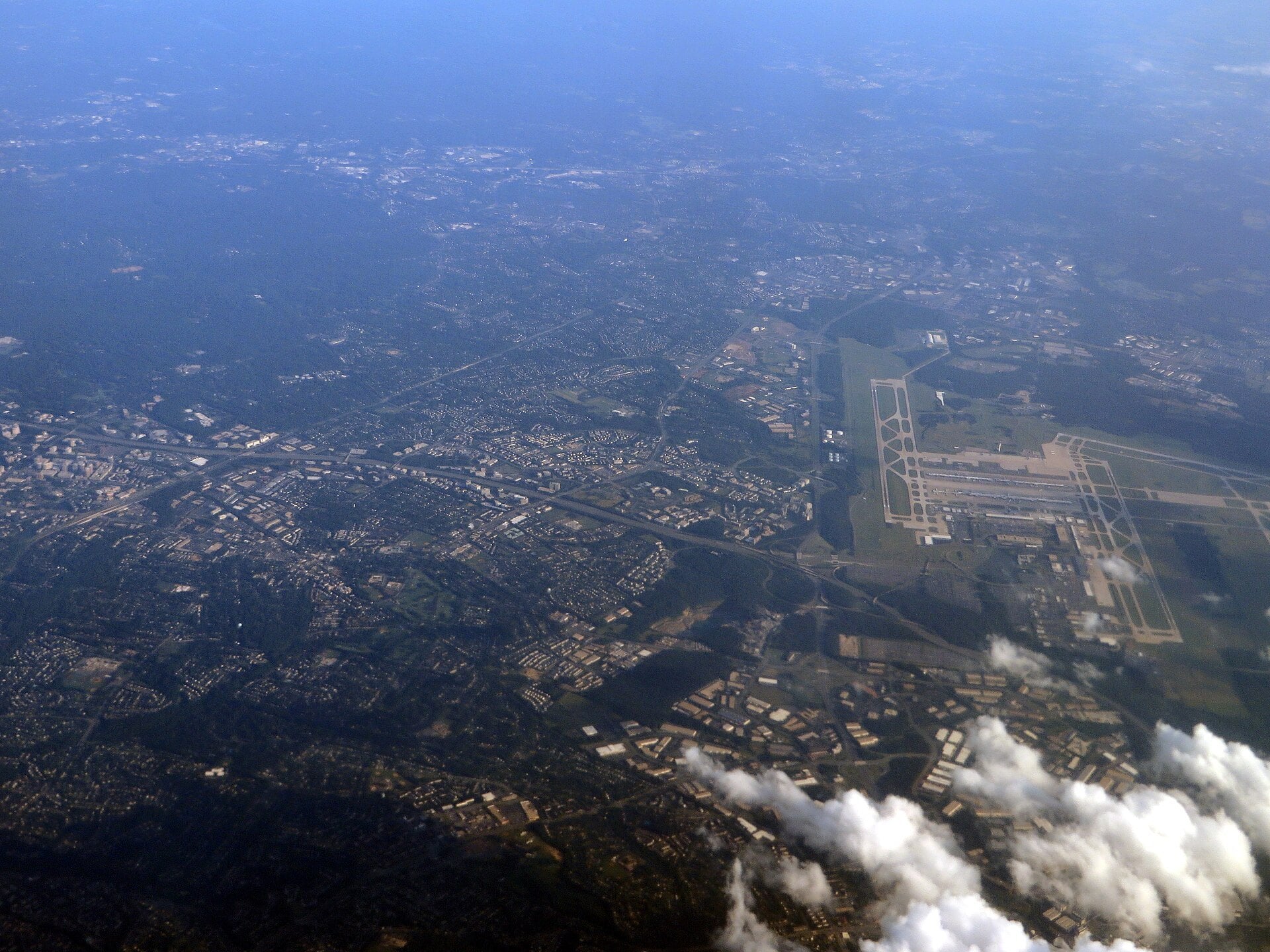 Aerial view of Washington Dulles International Airport's runways with Herndon and Reston spreading east toward Fairfax