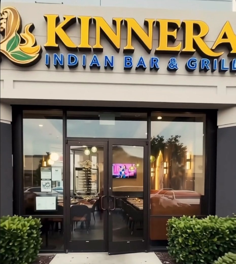 Storefront of Kinnera Indian Bar & Grill at Worldgate Centre in Herndon, with a gold and blue sign above glass doors