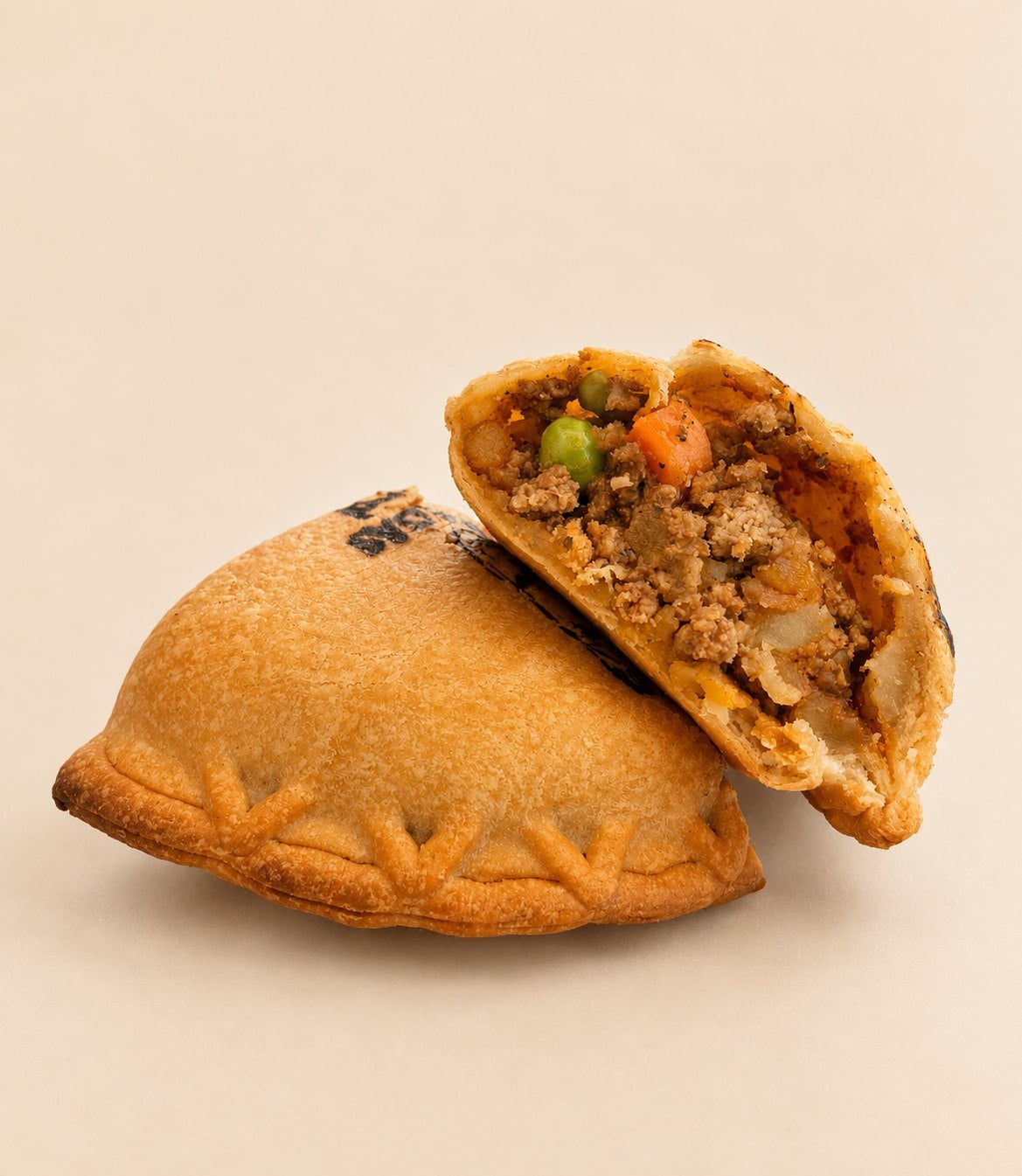 A Beef Papa empanada from Mpanadas broken open to show ground beef, potato, peas and carrots