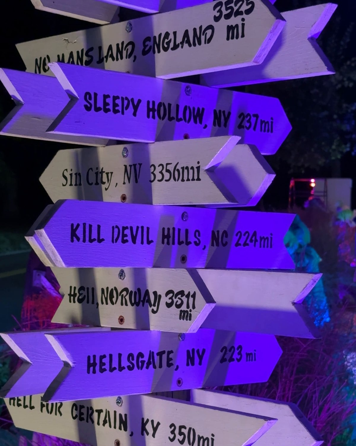 A signpost at the Historic Herndon Halloween House with arrows to Sleepy Hollow, Kill Devil Hills, Hellsgate and Hell for Certain