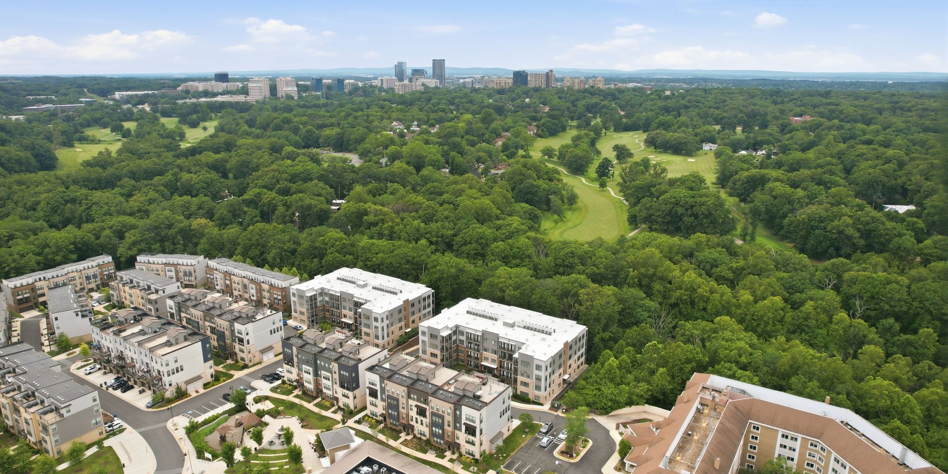 Aerial view of the townhouses and condominiums built on the old Tall Oaks Village Center site in Reston, Virginia, surrounded by woods