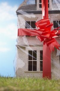 Model house gift-wrapped with red ribbon and bow, close-up