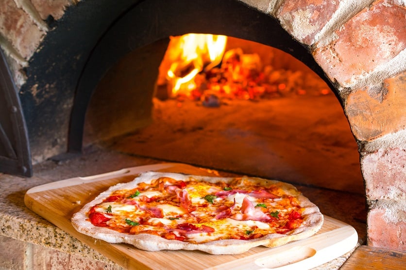 Rustic home-made pizza prosciutto baked in a wood fired brick oven with ...