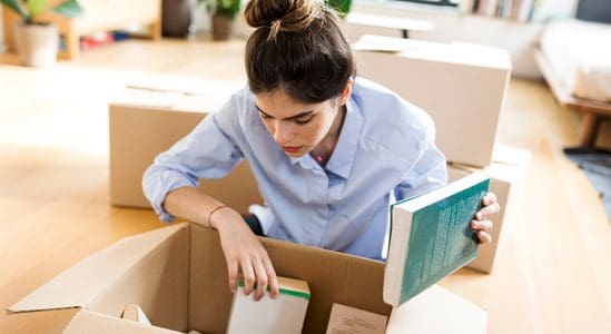 Woman opening boxes while moving in