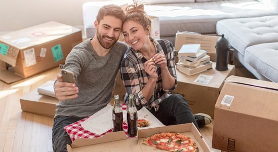 Young couple taking a selfie while eating