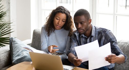 Couple discussing in front of laptop