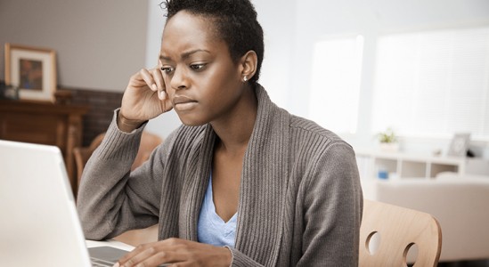Woman looking stressed while using laptop