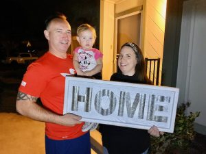 Client of Richard named Mitch and Eilleen holding a signage that says 'Home'