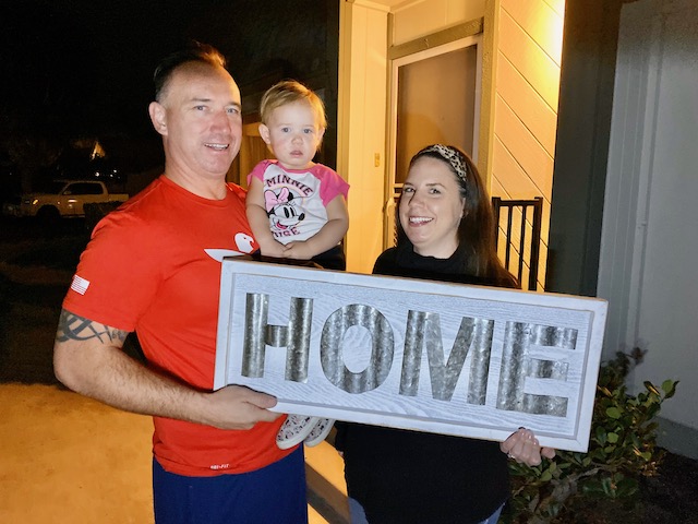 Client of Richard named Mitch and Eilleen holding a signage that says 'Home'