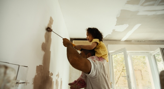 Dad and daughter painting the wall
