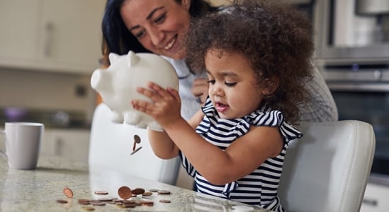Mom and daughter opening a piggy bank