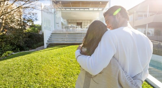 Young couple in front of new home