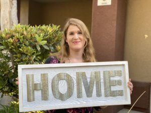 Woman holding a signage that says 'Home'