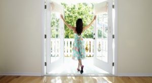 Woman dancing while opening door of house