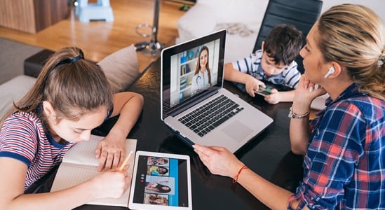Mother with 2 kids using laptop in a table