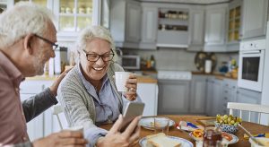 Close up of a senior couple having breakfast and using a phone