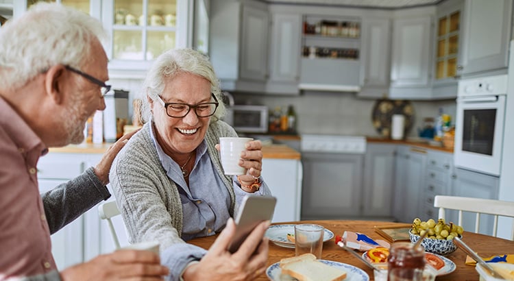 Close up of a senior couple having breakfast and using a phone
