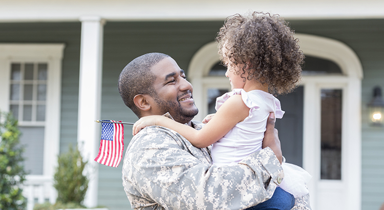 African American soldier returns from overseas holding his daughter
