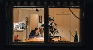 High angle view of boy studying while sitting at home seen through window