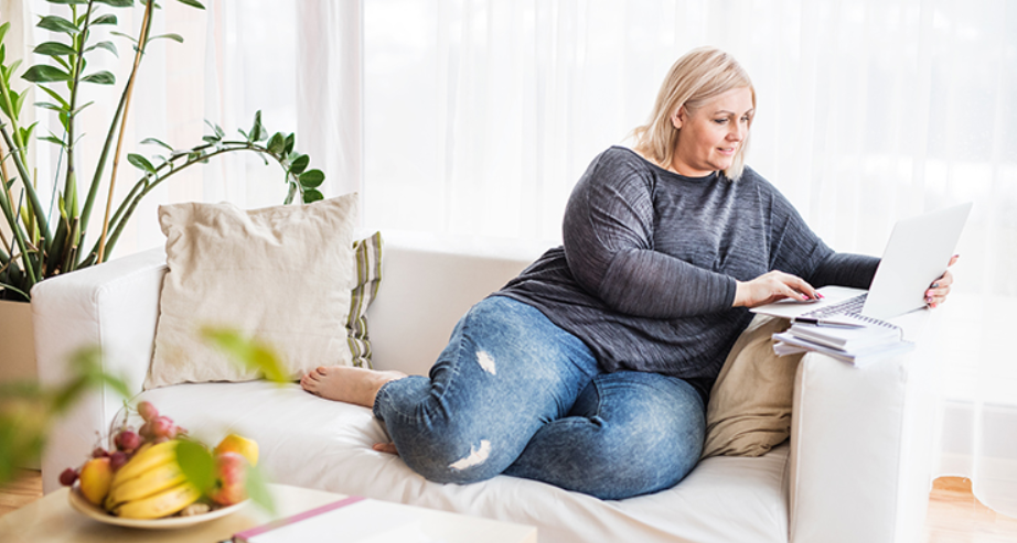 WOman sitting in a couch while using laptop