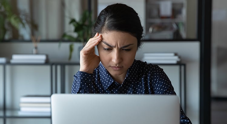 Stressed woman while looking at her laptop